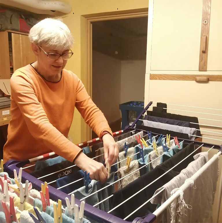 Frau mit einer Behinderung kümmert sich um die Wäsche