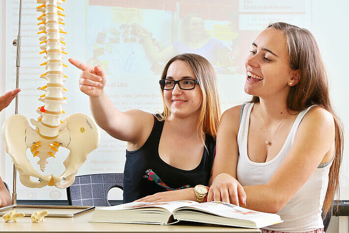 Drei Schülerinnen der Berufsfachschule für Diätassistenten in Neuendettelsau erlenen Fachwissen über die Anatomie des Menschen.
