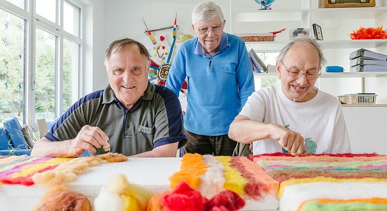 Senioren mit Behinderung basteln bunte Kunstwerke in der Seniorentagesstätte für Menschen mit Behinderung in Gunzenhausen