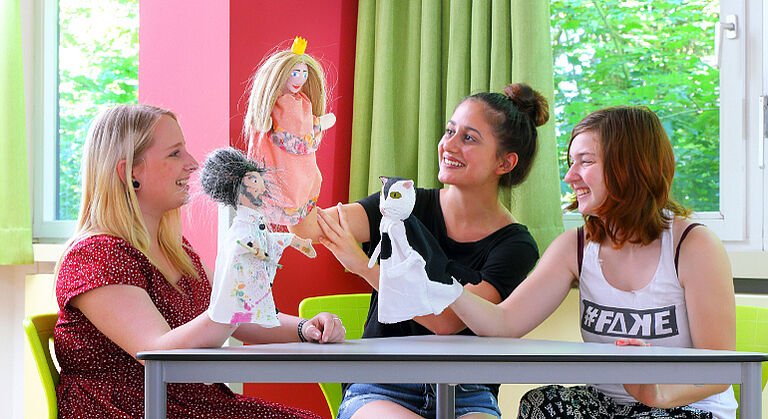 Drei Schülerinnen des Beruflichen Schulzentrums/BFS Kinderpflege spielen Puppentheater.