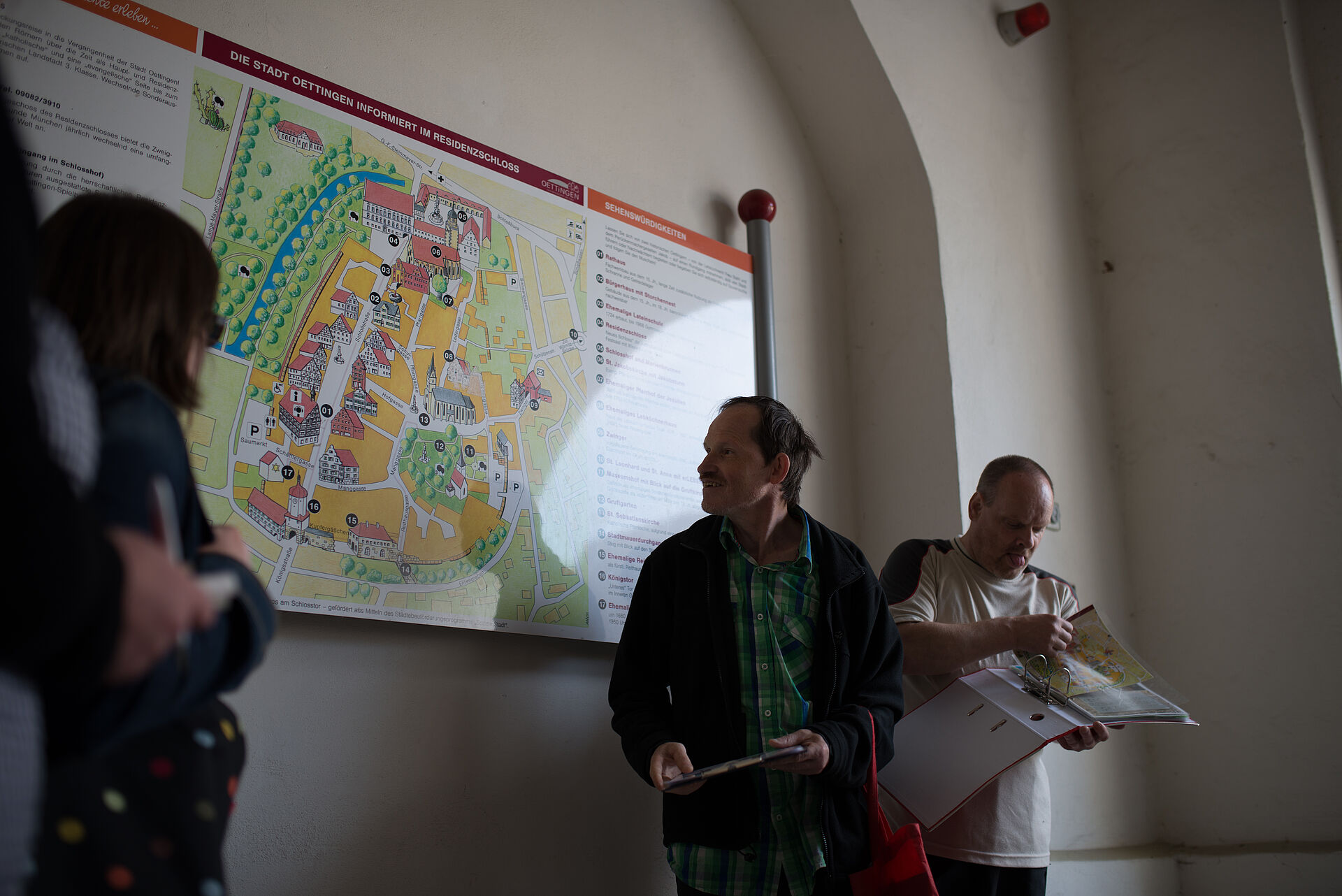 Stadtführer zeigt Route an Wandkarte von Oettingen