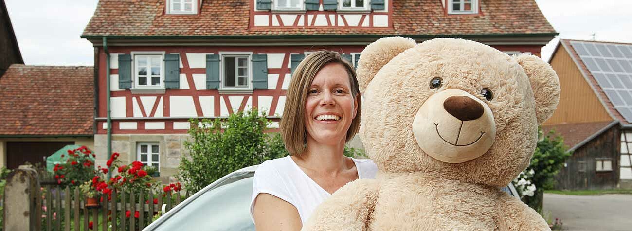 Eine Pflegekraft, die in der Kinderkrankenpflege arbeitet, hält zwei Teddys in der Hand.